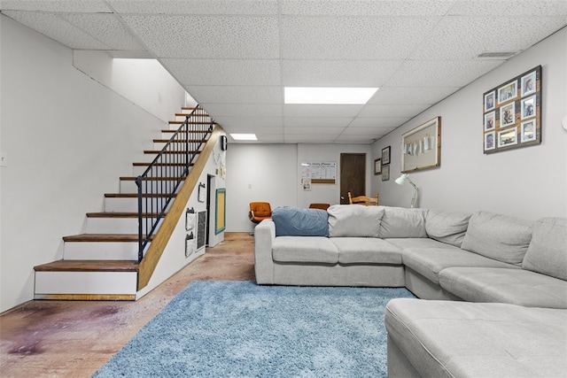 living room featuring concrete floors and a drop ceiling