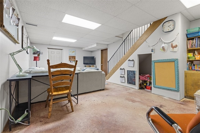 home office with concrete floors and a paneled ceiling