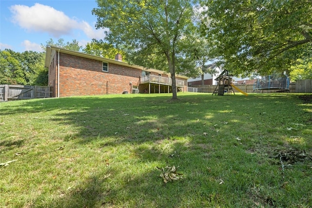 view of yard featuring a trampoline and a playground