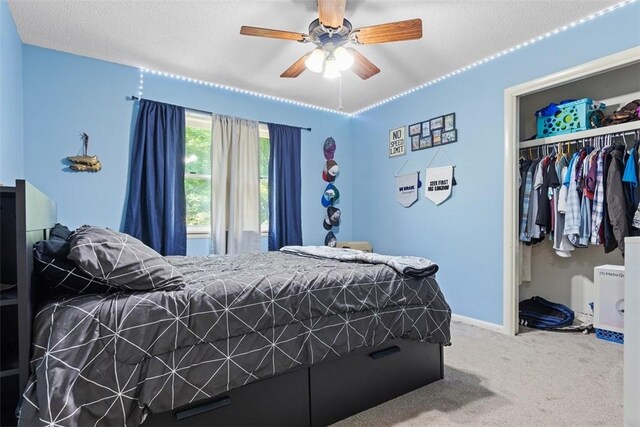 bedroom with a textured ceiling, a closet, ceiling fan, and carpet flooring