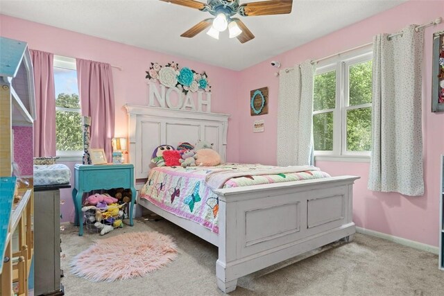 carpeted bedroom featuring ceiling fan and multiple windows