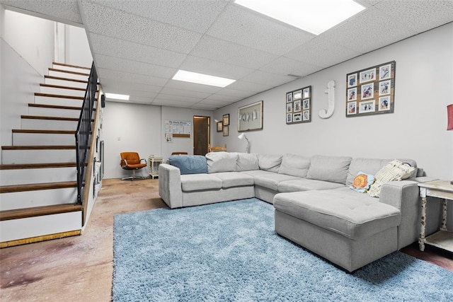 living room featuring a paneled ceiling and concrete floors