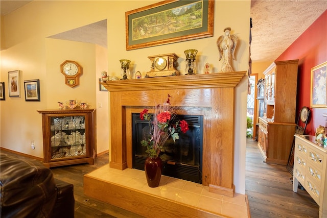 living room featuring a fireplace, a textured ceiling, and hardwood / wood-style flooring