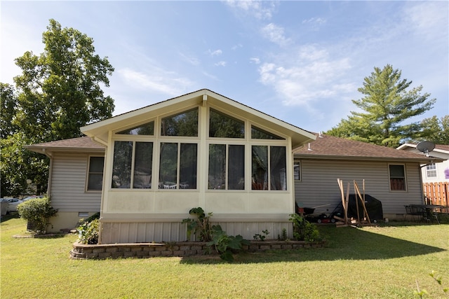 rear view of property with a sunroom and a yard