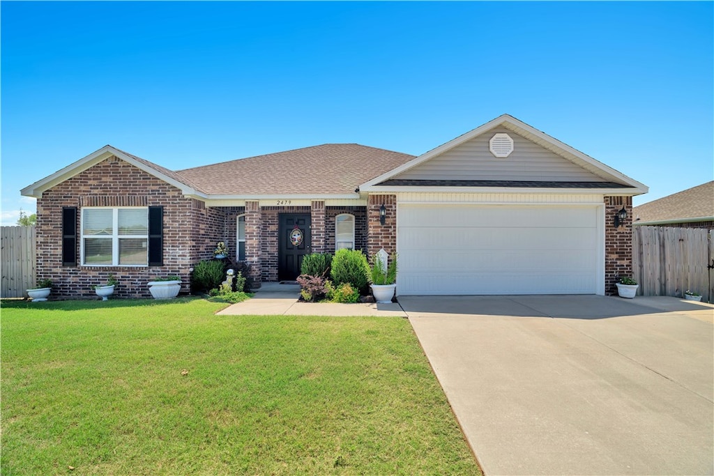 ranch-style house with a garage and a front lawn