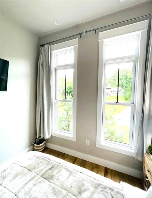 unfurnished bedroom featuring wood finished floors and baseboards