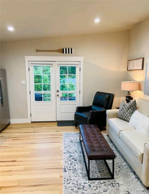 living area featuring baseboards, french doors, light wood finished floors, and recessed lighting