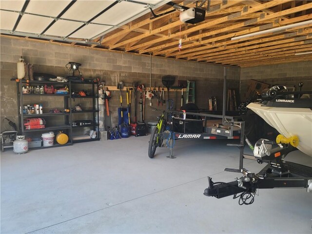 garage with concrete block wall and a garage door opener