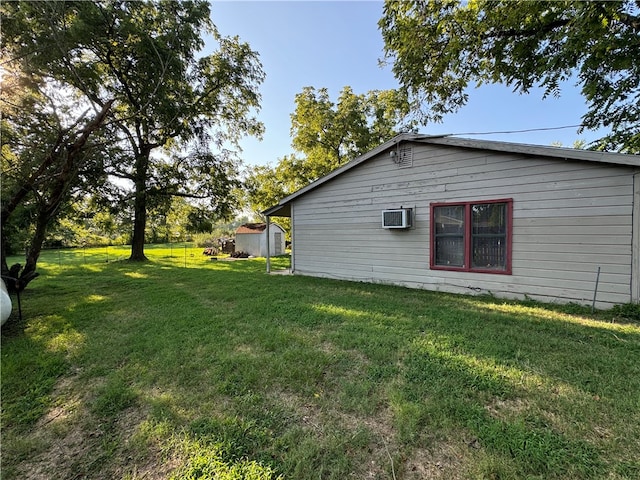 exterior space with a storage shed, a yard, and a wall unit AC