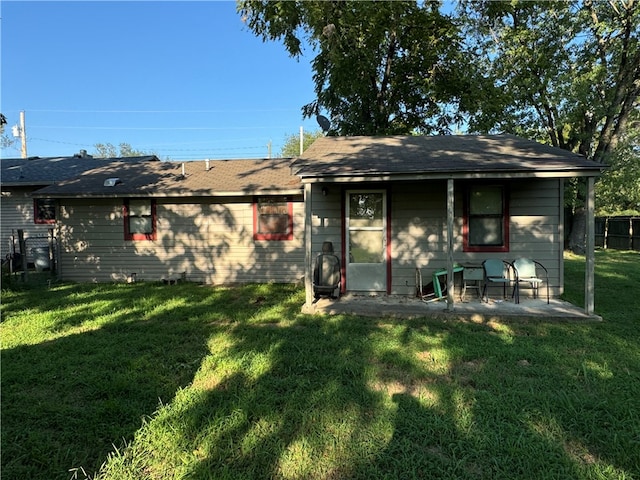 rear view of house with a patio and a yard