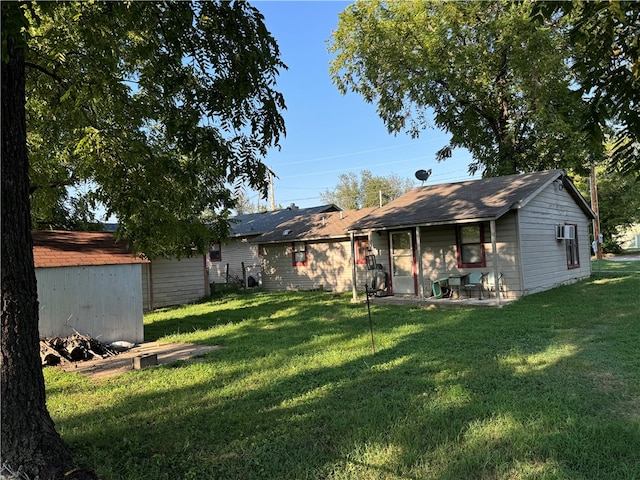 rear view of house featuring a storage shed and a lawn