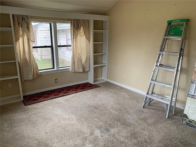 carpeted empty room featuring lofted ceiling