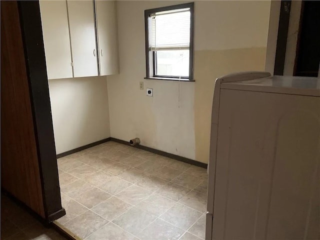 interior space featuring light tile patterned floors, washer / clothes dryer, and cabinets