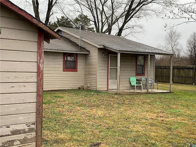 rear view of house featuring a patio area and a yard