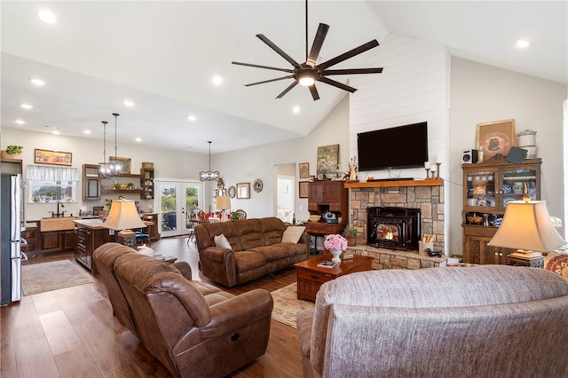 living room featuring ceiling fan, high vaulted ceiling, wood-type flooring, french doors, and a fireplace