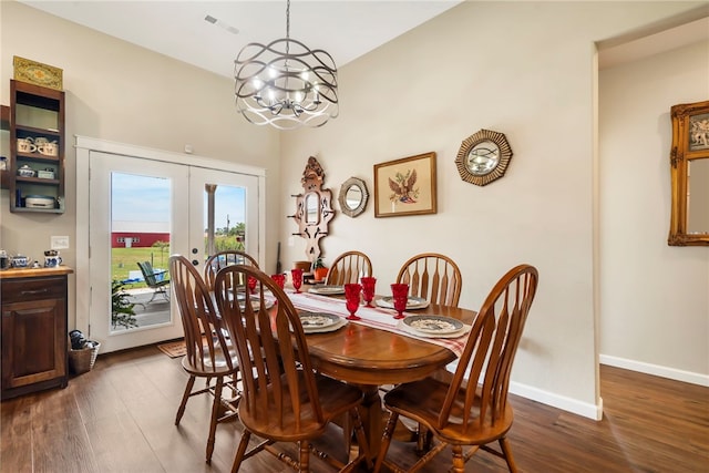 dining space with dark hardwood / wood-style flooring, an inviting chandelier, and french doors