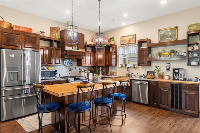 kitchen with wooden counters, stainless steel appliances, a kitchen island, and dark hardwood / wood-style flooring