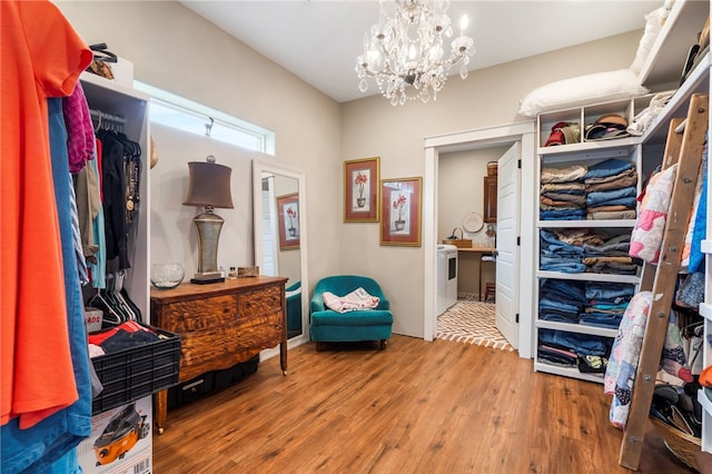 spacious closet with hardwood / wood-style floors and a chandelier