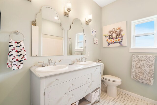 bathroom featuring tile patterned flooring, toilet, and vanity