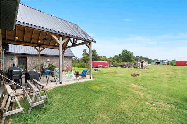 view of yard featuring ceiling fan, a patio area, and a shed