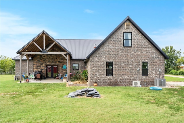 rear view of property featuring a patio area, a yard, and central air condition unit