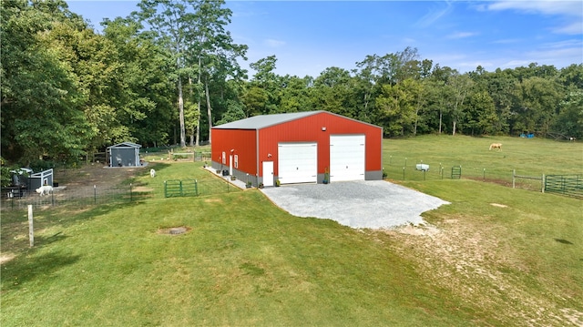 garage featuring a rural view and a lawn