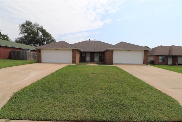 single story home featuring a garage, driveway, and a front lawn