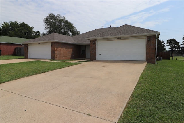 ranch-style house featuring a garage and a front lawn