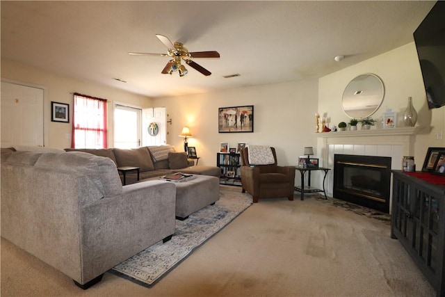 living area featuring carpet floors, visible vents, a fireplace, and ceiling fan