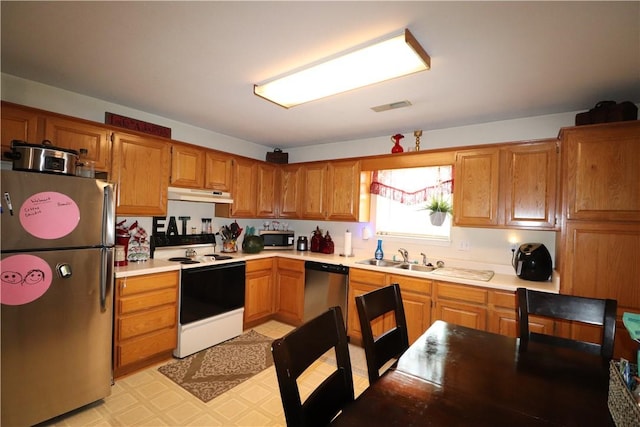 kitchen with visible vents, appliances with stainless steel finishes, light countertops, under cabinet range hood, and a sink