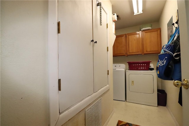 laundry area featuring separate washer and dryer, cabinet space, and visible vents