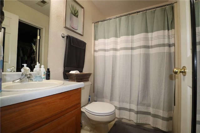 full bathroom featuring toilet, curtained shower, visible vents, and vanity