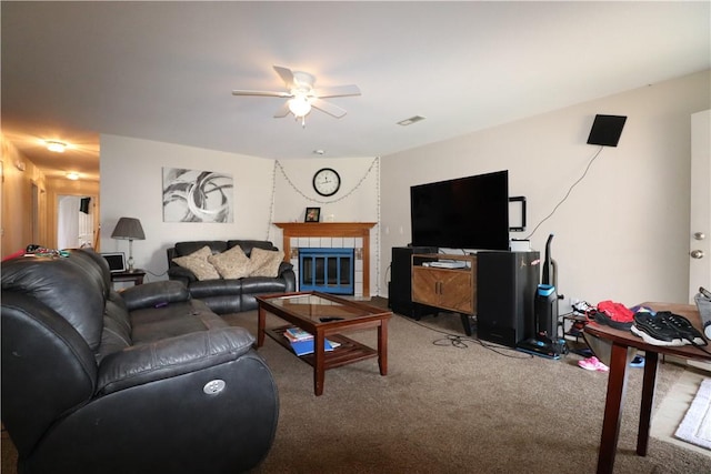 carpeted living room featuring a fireplace and ceiling fan