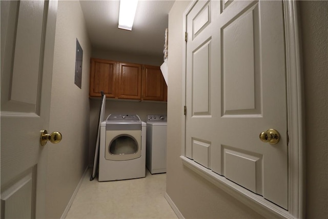 laundry room featuring light floors, independent washer and dryer, cabinet space, and baseboards