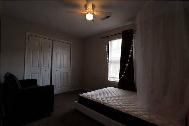 carpeted bedroom with a closet, visible vents, and ceiling fan