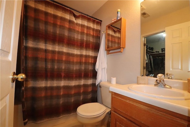 bathroom featuring a shower with shower curtain, visible vents, vanity, and toilet