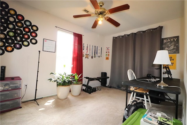 carpeted office with a ceiling fan and visible vents