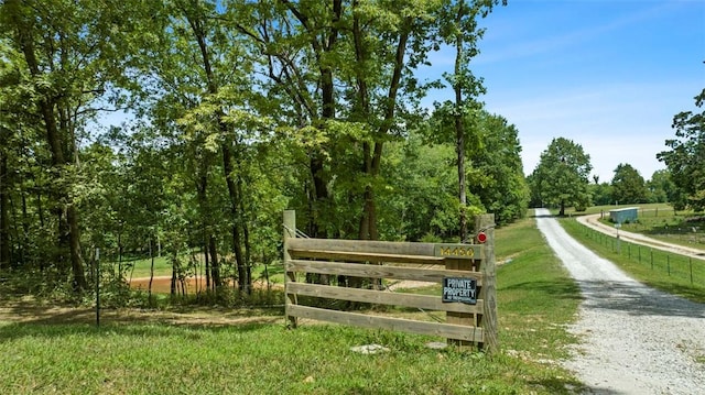 view of community featuring driveway and fence