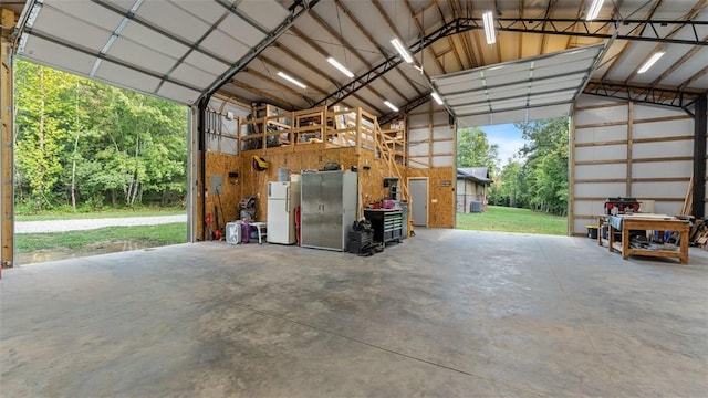 garage with metal wall and freestanding refrigerator