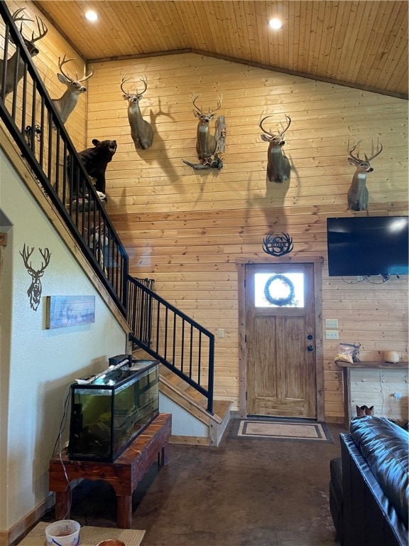 entryway with wood walls, lofted ceiling, and wooden ceiling