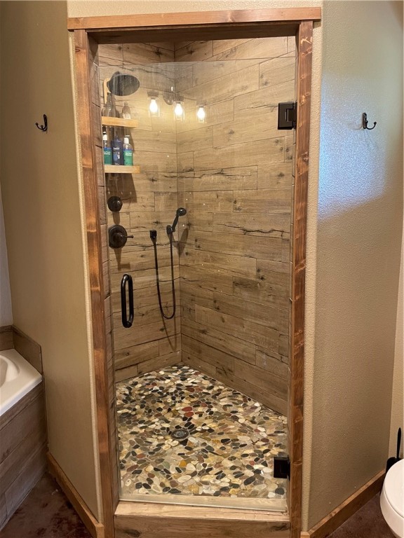 bathroom featuring toilet and separate shower and tub