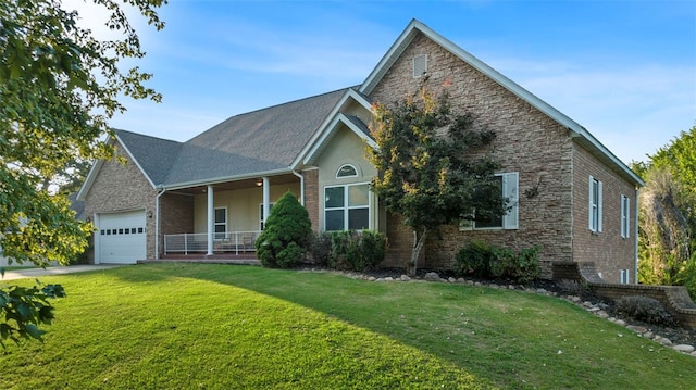 front facade with covered porch, a front yard, and a garage