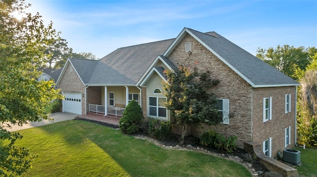 view of front facade with a garage, a front yard, and cooling unit