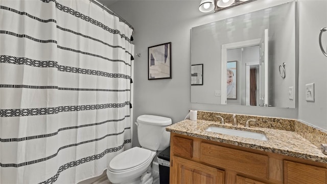 bathroom with vanity, toilet, and walk in shower