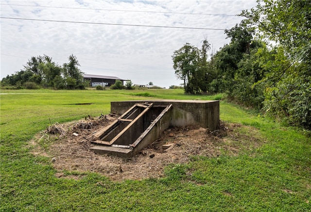 entry to storm shelter featuring a lawn