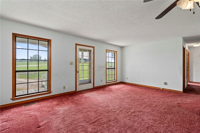 empty room with a textured ceiling, carpet flooring, and ceiling fan