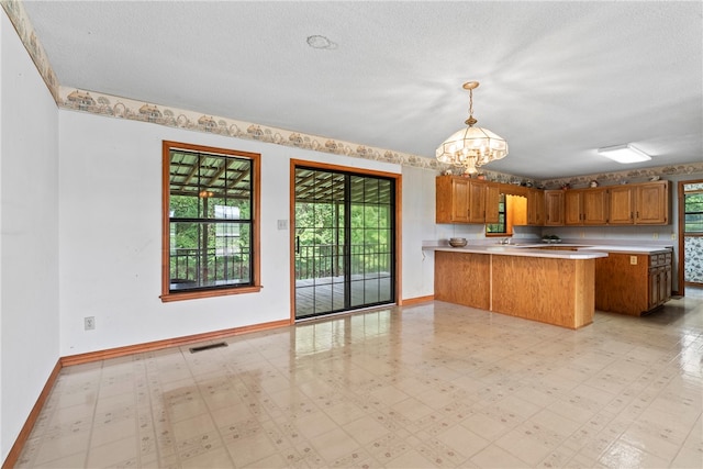 kitchen featuring a wealth of natural light, pendant lighting, and a textured ceiling