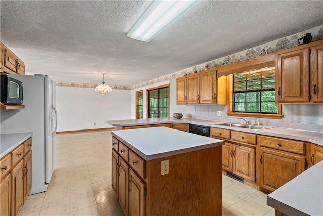 kitchen featuring a center island, sink, a textured ceiling, and light tile patterned flooring