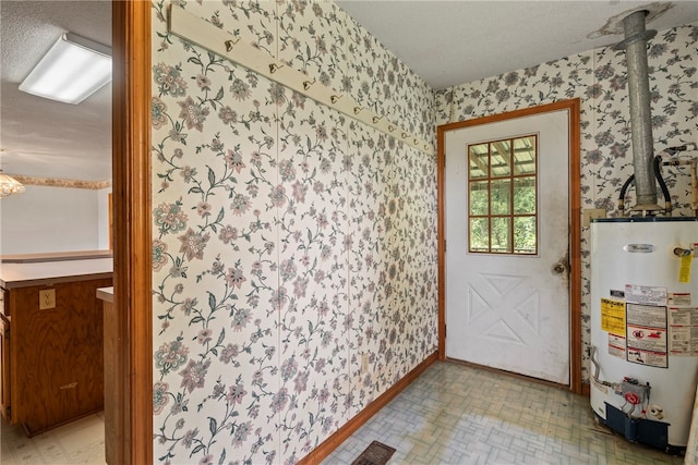 entryway with a textured ceiling, gas water heater, and light tile patterned floors