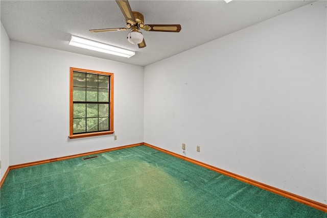 carpeted spare room featuring a textured ceiling and ceiling fan